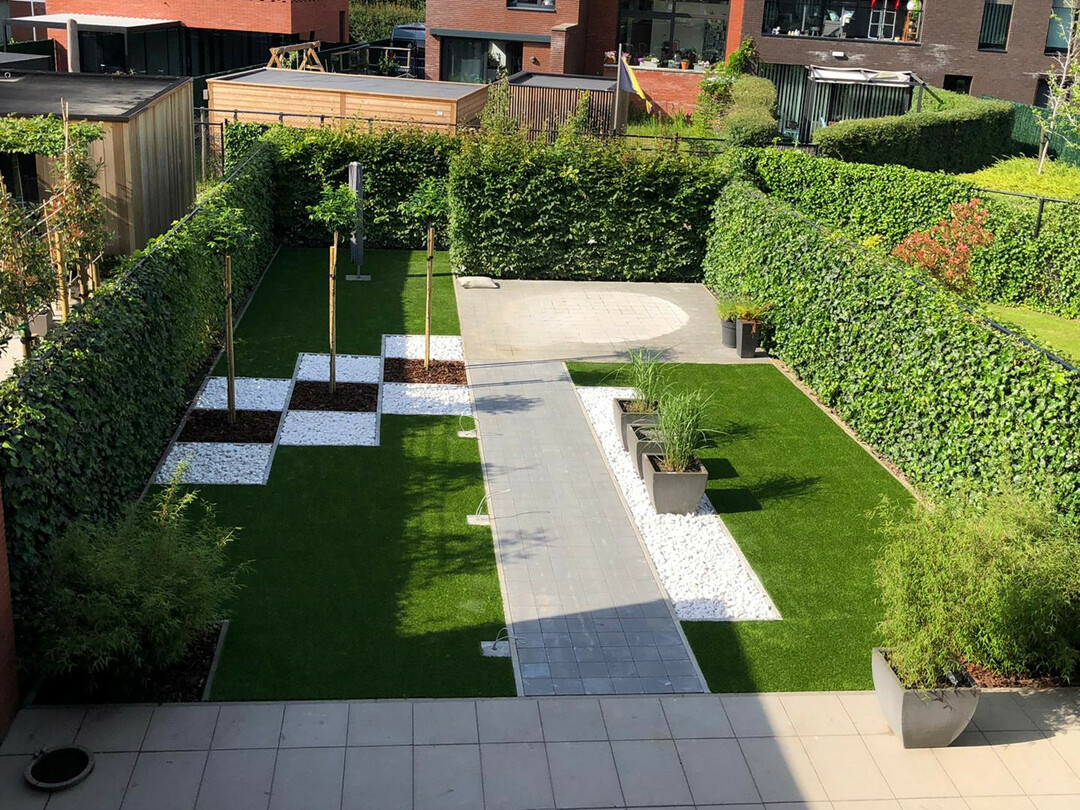 kleine stadstuin met kunstgras en klinkerpad